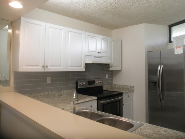 kitchen featuring white cabinetry, appliances with stainless steel finishes, a textured ceiling, and backsplash