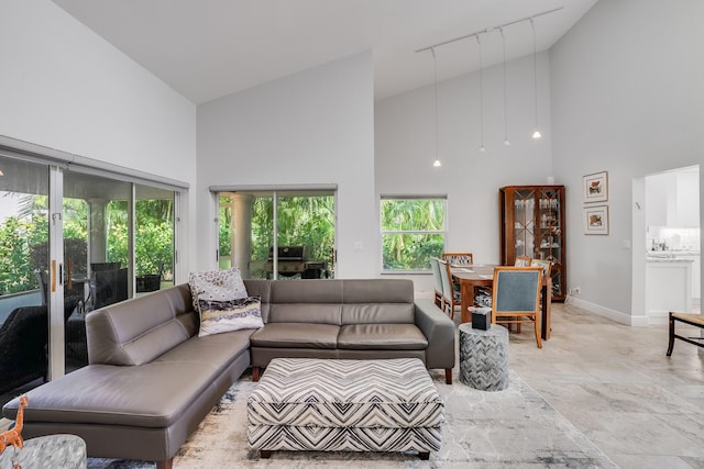 living room featuring high vaulted ceiling and track lighting