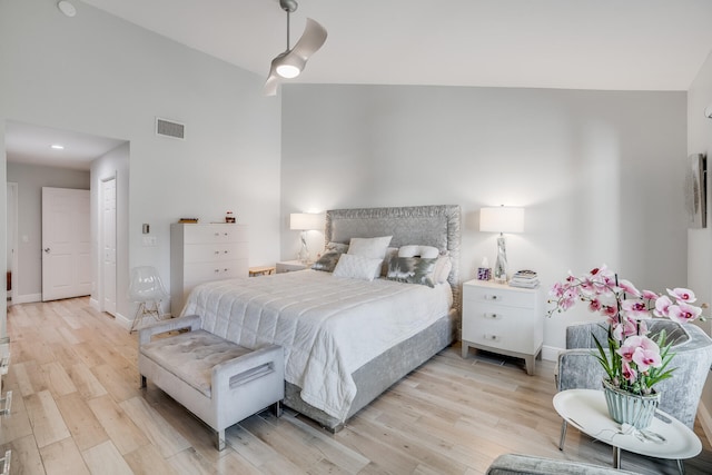 bedroom with ceiling fan, light wood-type flooring, and high vaulted ceiling