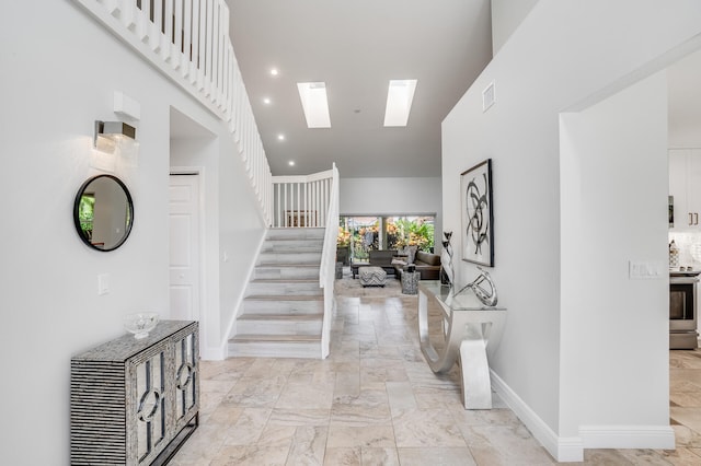 foyer entrance with a skylight and a high ceiling