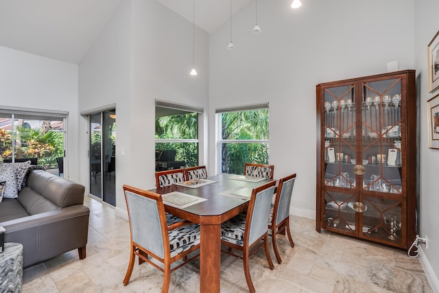 dining space with high vaulted ceiling