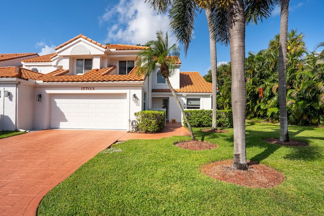 mediterranean / spanish-style house with a garage and a front yard