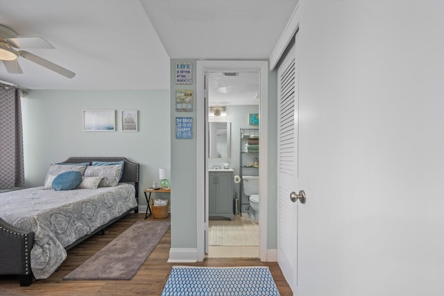 bedroom with a closet, ensuite bath, ceiling fan, and dark hardwood / wood-style flooring