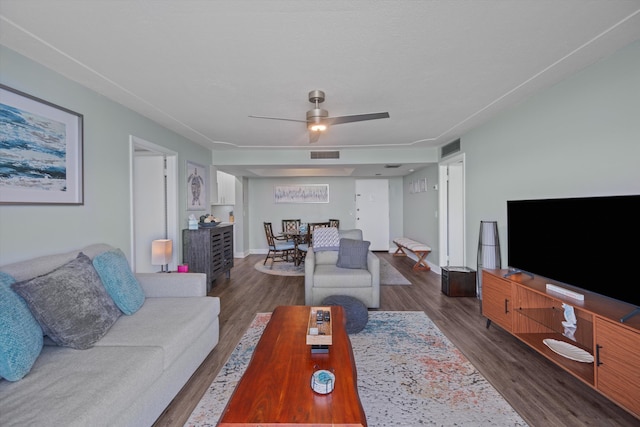 living room with dark hardwood / wood-style flooring and ceiling fan