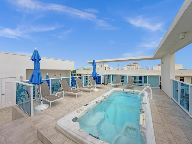 view of pool with a patio area and a hot tub