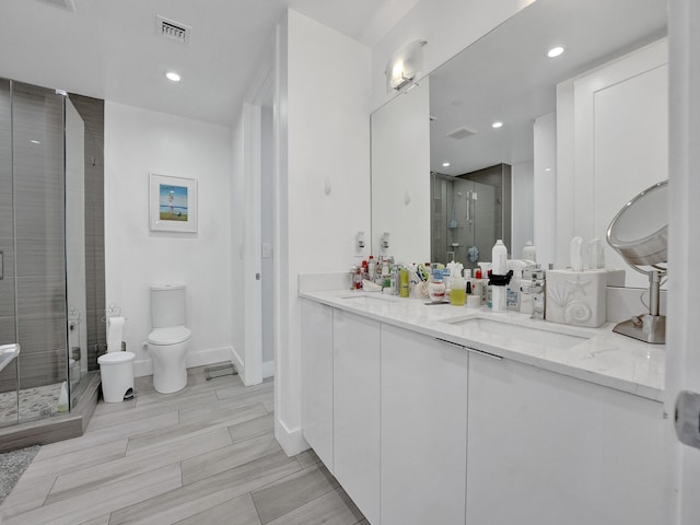 bathroom featuring vanity, toilet, and walk in shower