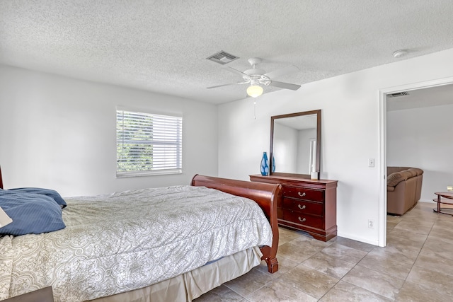 bedroom with ceiling fan and a textured ceiling