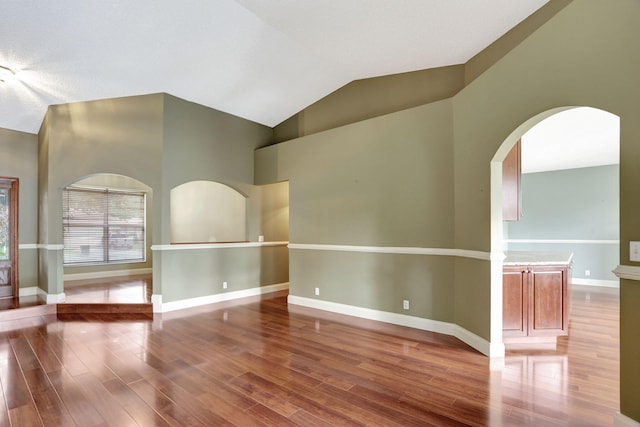 unfurnished room featuring wood-type flooring and vaulted ceiling