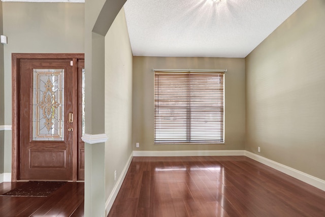 foyer entrance with hardwood / wood-style floors and a textured ceiling