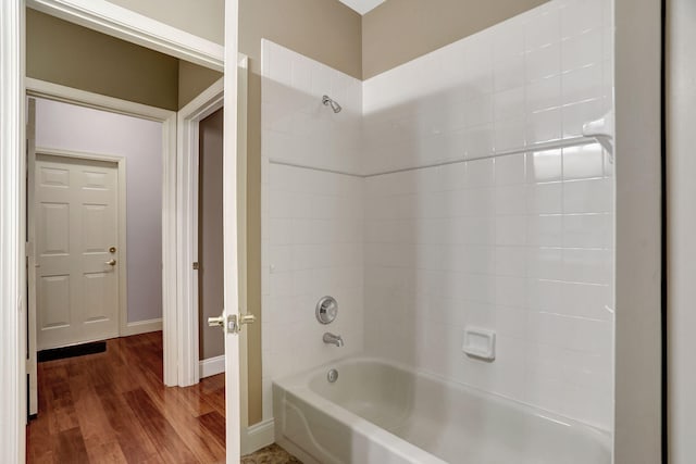 bathroom with tiled shower / bath combo and wood-type flooring