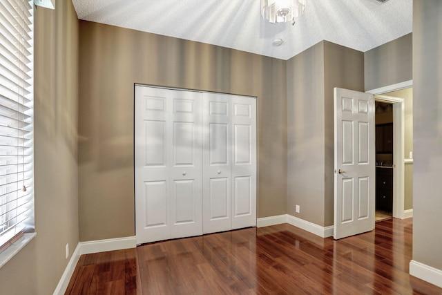 unfurnished bedroom with hardwood / wood-style floors, a textured ceiling, and a closet