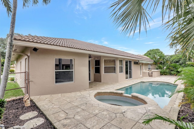 back of property with a pool with hot tub, a patio, and ceiling fan