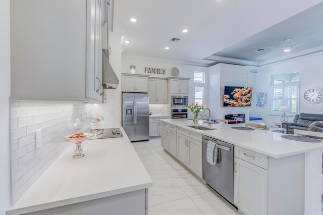 kitchen with decorative backsplash, appliances with stainless steel finishes, a kitchen island with sink, and sink