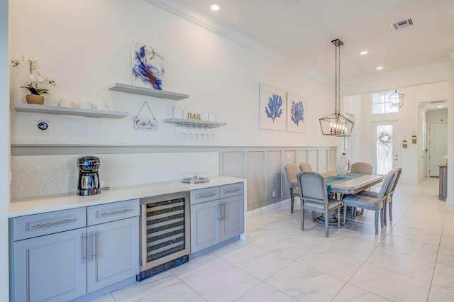 kitchen featuring hanging light fixtures, beverage cooler, and ornamental molding