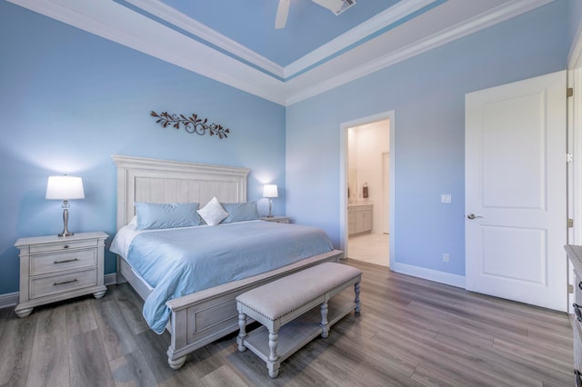 bedroom with connected bathroom, ceiling fan, light hardwood / wood-style flooring, and crown molding