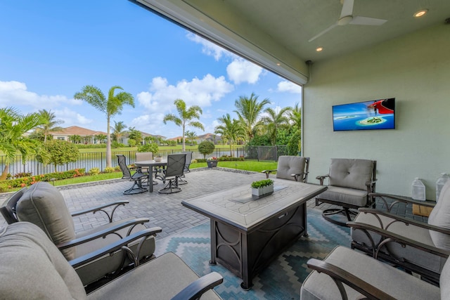 view of patio featuring ceiling fan, a water view, and an outdoor hangout area