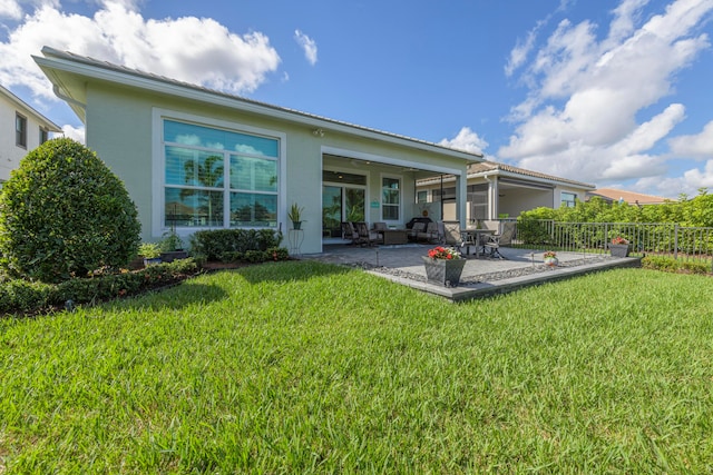 rear view of house with a patio area and a lawn