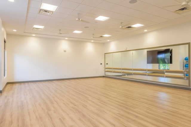 interior space with a drop ceiling and light hardwood / wood-style flooring