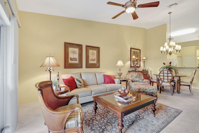 tiled living room with ceiling fan with notable chandelier