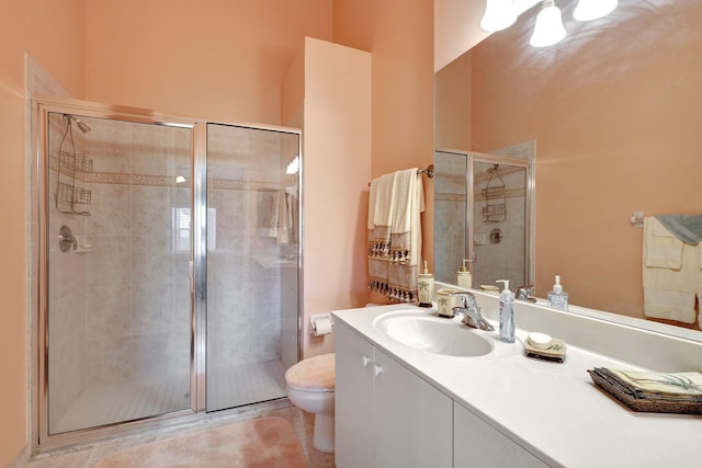 bathroom with tile patterned floors, vanity, toilet, and a shower with shower door