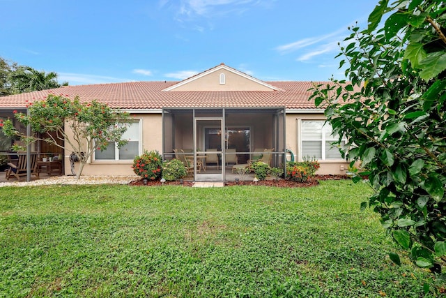 rear view of property featuring a lawn