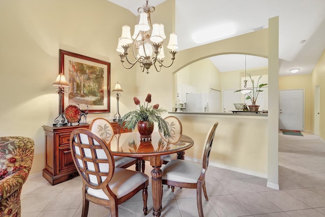 dining space featuring vaulted ceiling, a notable chandelier, and light tile patterned floors