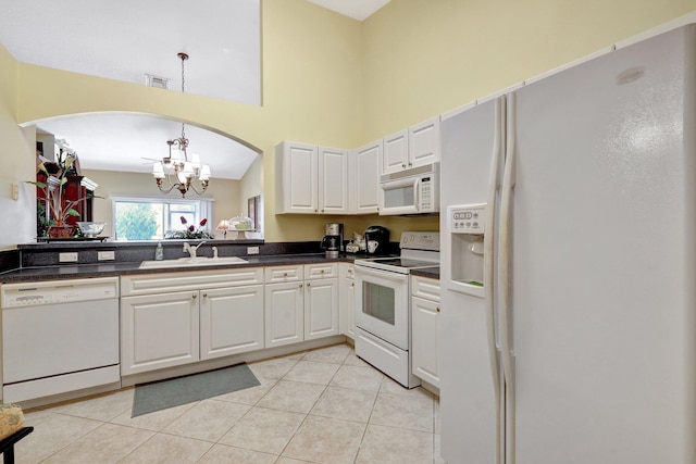 kitchen featuring white cabinets, white appliances, sink, and a chandelier