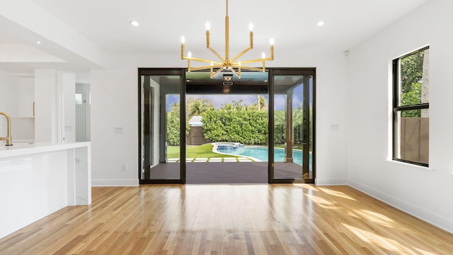 interior space featuring an inviting chandelier and light hardwood / wood-style flooring