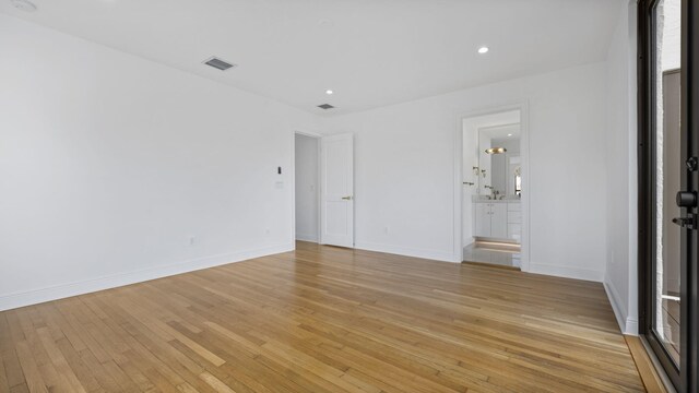 empty room featuring french doors, light wood-type flooring, and a healthy amount of sunlight