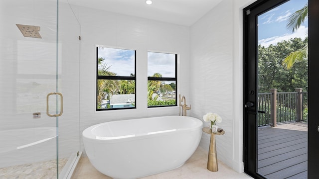 bathroom with tile patterned floors, shower with separate bathtub, and tile walls