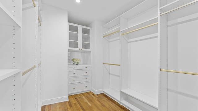 walk in closet with light hardwood / wood-style flooring