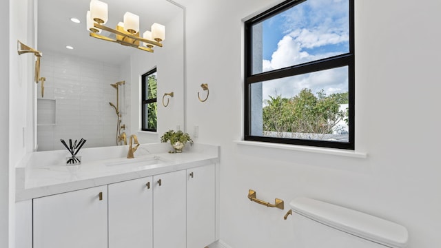 bathroom featuring toilet, vanity, and a tile shower