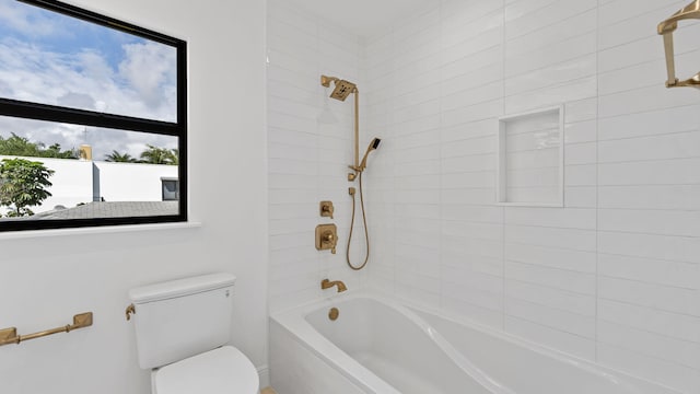 bathroom with tiled shower / bath and toilet