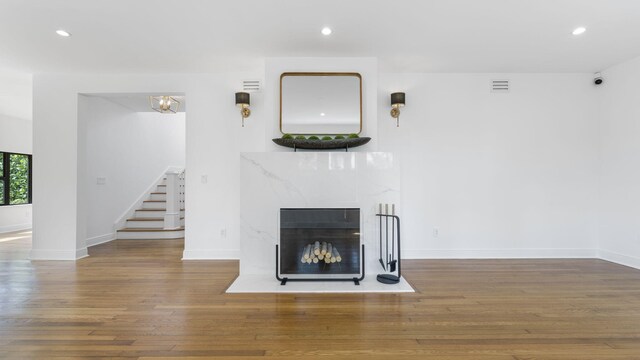 unfurnished living room featuring wood-type flooring and a high end fireplace