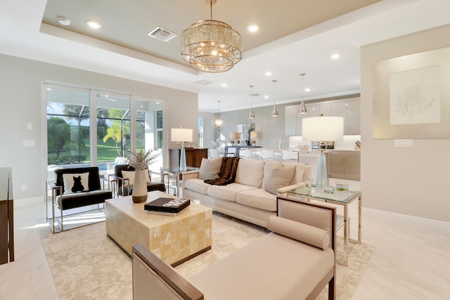 living room with an inviting chandelier and a raised ceiling