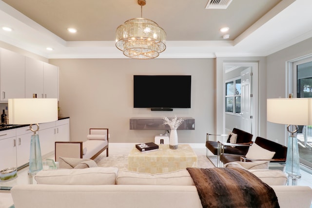 living room featuring a tray ceiling and a notable chandelier