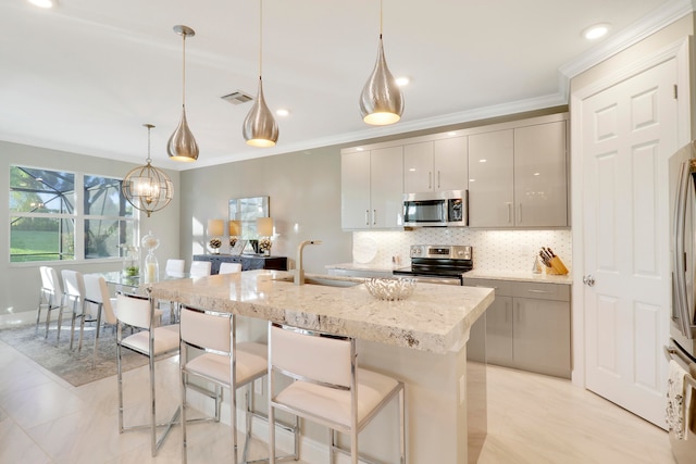 kitchen with gray cabinetry, crown molding, sink, appliances with stainless steel finishes, and decorative light fixtures