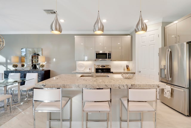 kitchen with appliances with stainless steel finishes, backsplash, light stone counters, sink, and pendant lighting