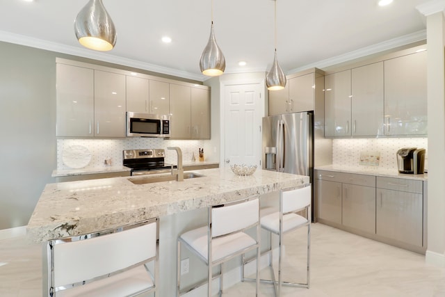 kitchen with ornamental molding, hanging light fixtures, appliances with stainless steel finishes, and tasteful backsplash