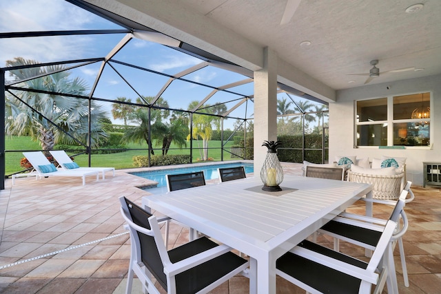 view of patio featuring ceiling fan and glass enclosure