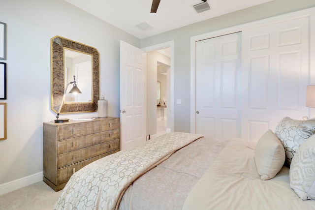 bedroom with ceiling fan, light colored carpet, and a closet