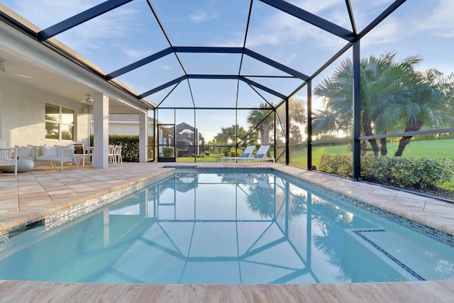 view of swimming pool with a lanai, ceiling fan, and a patio area