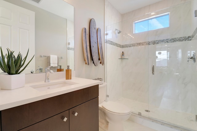 bathroom with vanity, toilet, and a shower with shower door