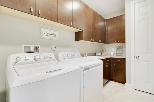 laundry area with washing machine and clothes dryer, sink, and cabinets