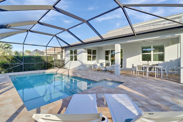 view of swimming pool featuring ceiling fan, a patio area, a jacuzzi, and glass enclosure