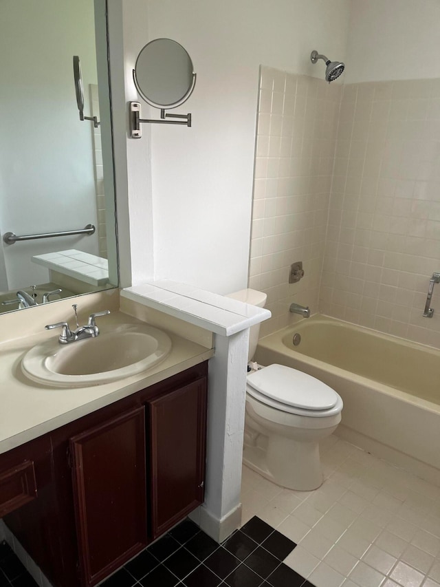 full bathroom featuring tile patterned flooring, vanity, tiled shower / bath combo, and toilet