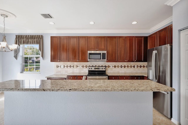 kitchen featuring tasteful backsplash, crown molding, pendant lighting, a kitchen island, and appliances with stainless steel finishes