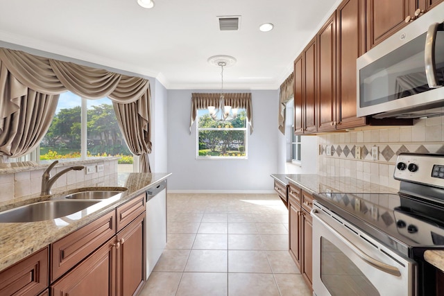 kitchen with crown molding, sink, decorative backsplash, appliances with stainless steel finishes, and a notable chandelier