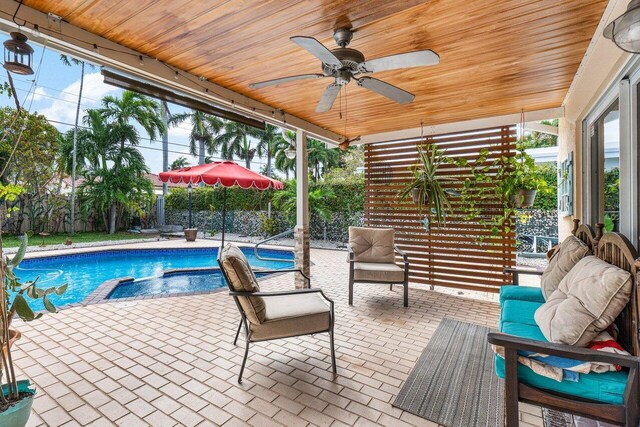 exterior space featuring ceiling fan, a patio area, a fenced backyard, and a pool with connected hot tub