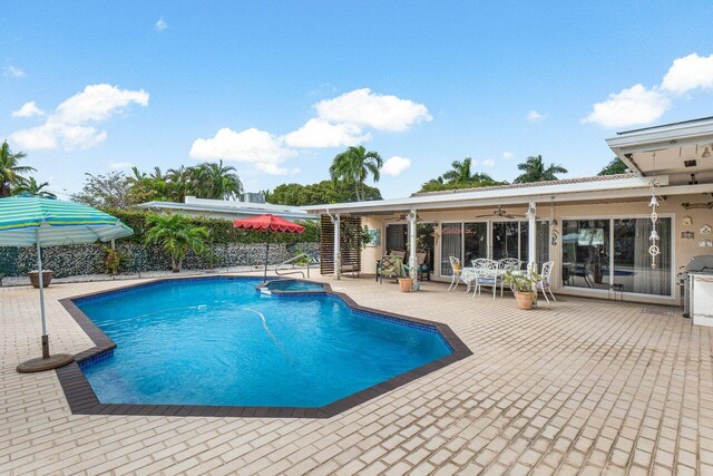 view of swimming pool featuring a patio, a pool with connected hot tub, and a ceiling fan